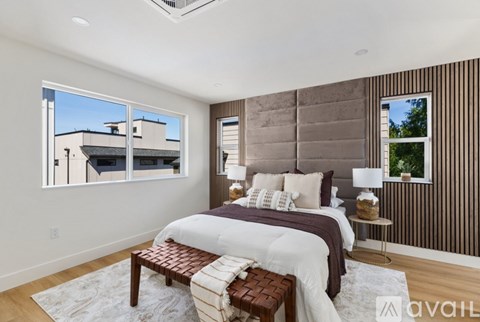 A bedroom with a large bed and a window overlooking a building.