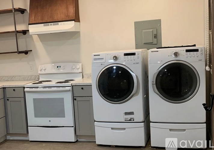 A white oven and washing machine are in a kitchen.