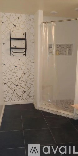 A bathroom with a black tiled floor and a white shower curtain.