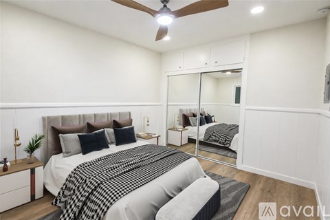 A bedroom with a large bed and a ceiling fan.