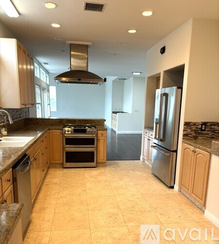A kitchen with a stainless steel refrigerator and oven.