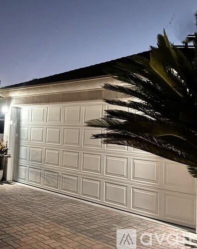 A white garage door is illuminated from the inside.