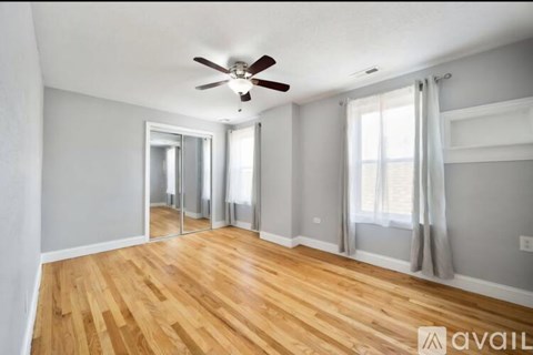 A room with wooden floors and a ceiling fan.