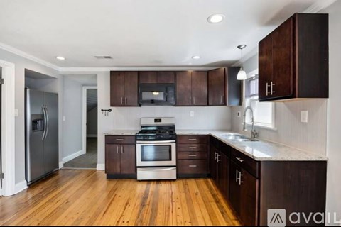 A kitchen with wooden cabinets and a stainless steel refrigerator.