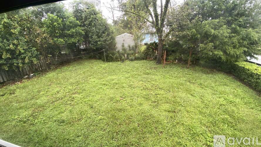 A backyard with a well-maintained lawn and trees.
