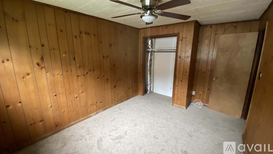 A room with wooden walls and a ceiling fan.