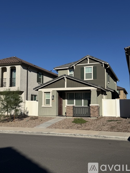 A house with a brown roof and a grey facade is for sale.
