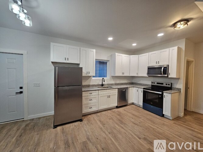 A kitchen with white cabinets and stainless steel appliances.