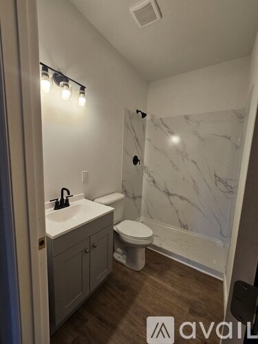 A bathroom with a marble wall and a toilet.
