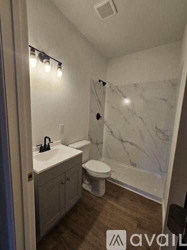 A bathroom with a marble wall and a toilet.