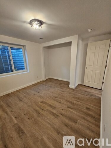 A room with wooden flooring and a white door.