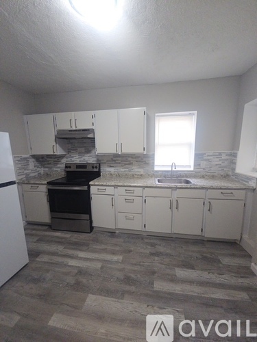 A kitchen with a white fridge and cabinets.
