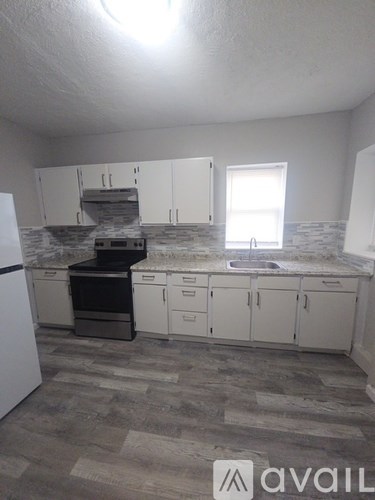 A kitchen with a white fridge and cabinets.