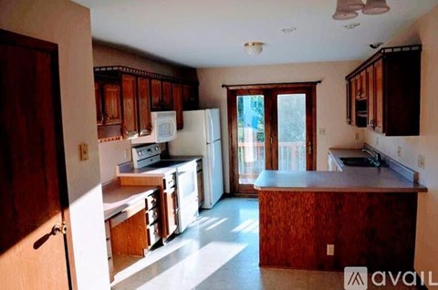 A kitchen with wooden cabinets and a white refrigerator.