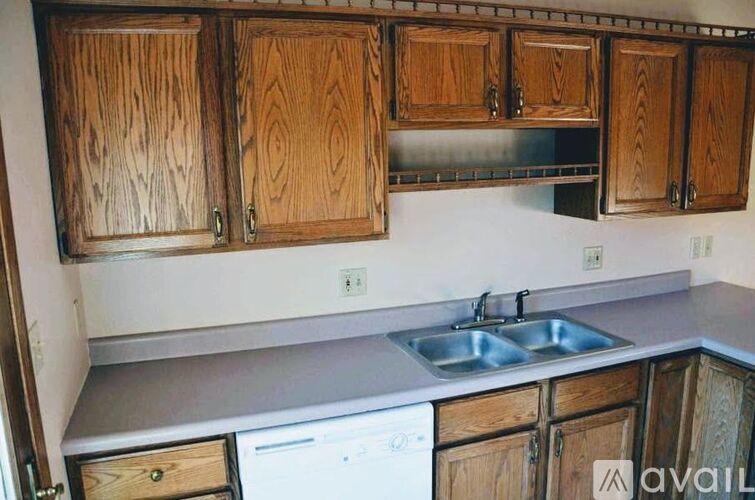 A kitchen with wooden cabinets and a white dishwasher.