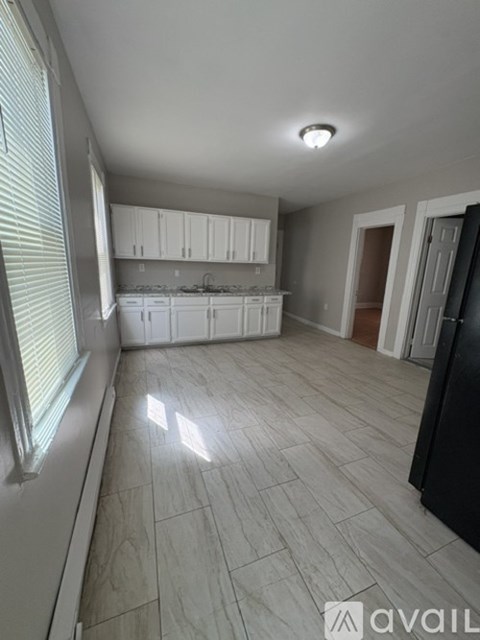 A kitchen with white cabinets and a tiled floor.