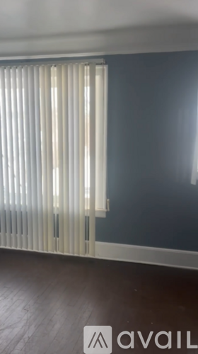 A room with a window covered by vertical blinds.