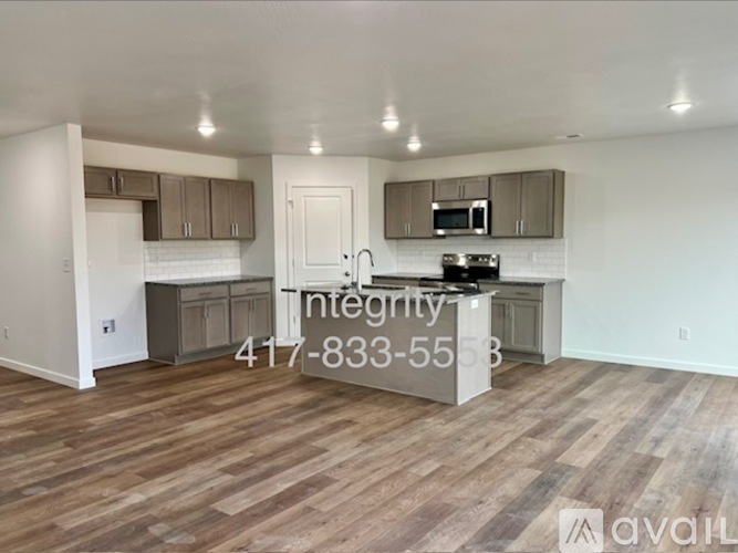 A kitchen with wooden floors and a countertop with a microwave and oven.