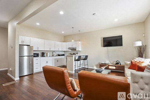 A modern kitchen with white cabinets and a wooden floor.