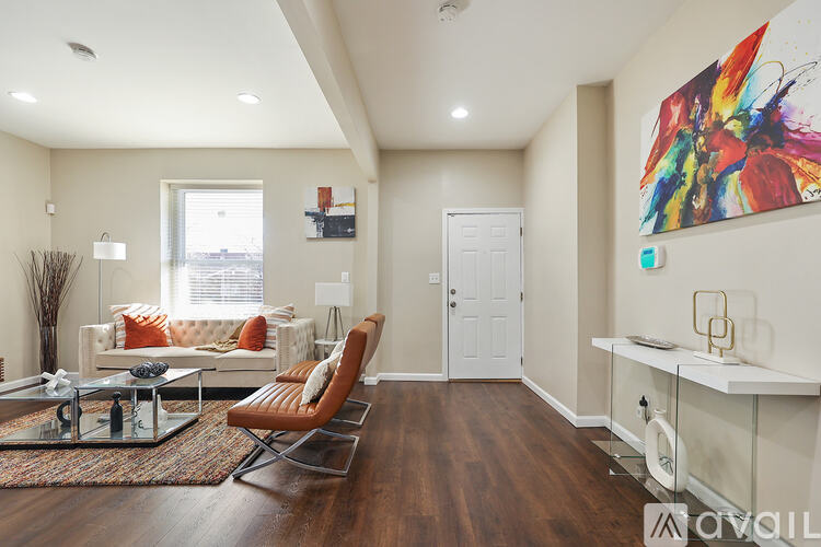A living room with a white couch and a colorful painting on the wall.