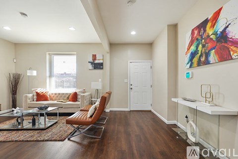 A living room with a white couch and a colorful painting on the wall.