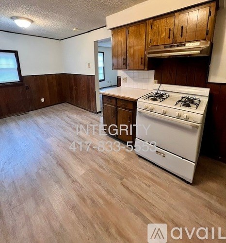 A kitchen with a white stove and wooden cabinets.