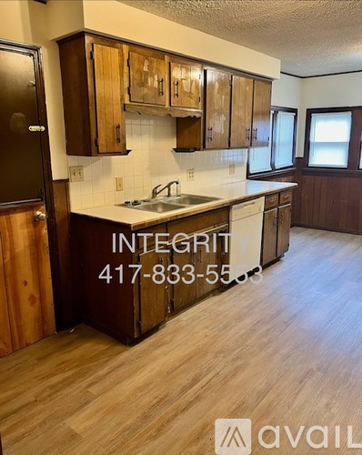 A kitchen with wooden cabinets and a countertop with a sink.