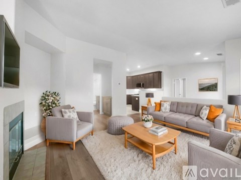 A modern living room with a grey sofa, a coffee table, and a fireplace.
