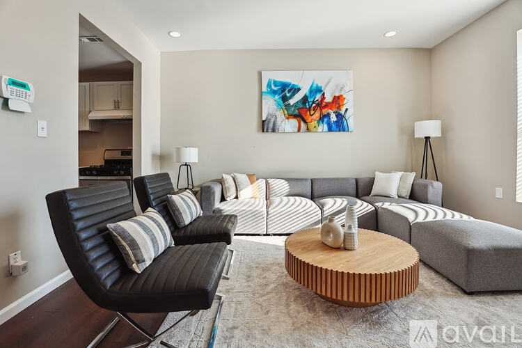 A living room with a black leather chair and a wooden coffee table.