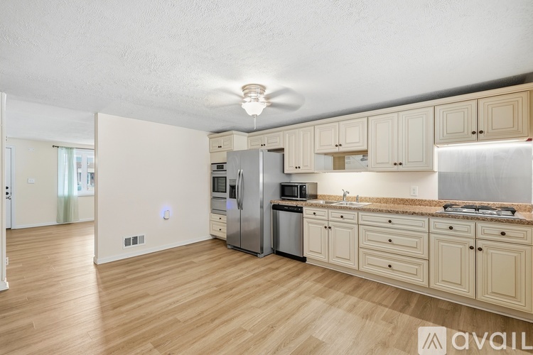 A kitchen with wooden floors and a refrigerator.