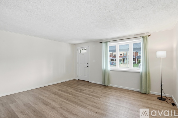 A room with a wooden floor and a window with a view of the outside.