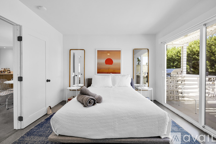 A bedroom with a large bed and a painting on the wall.