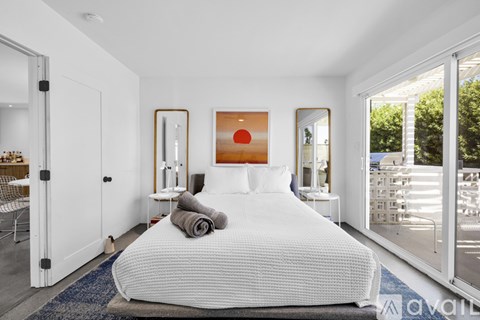 A bedroom with a large bed and a painting on the wall.