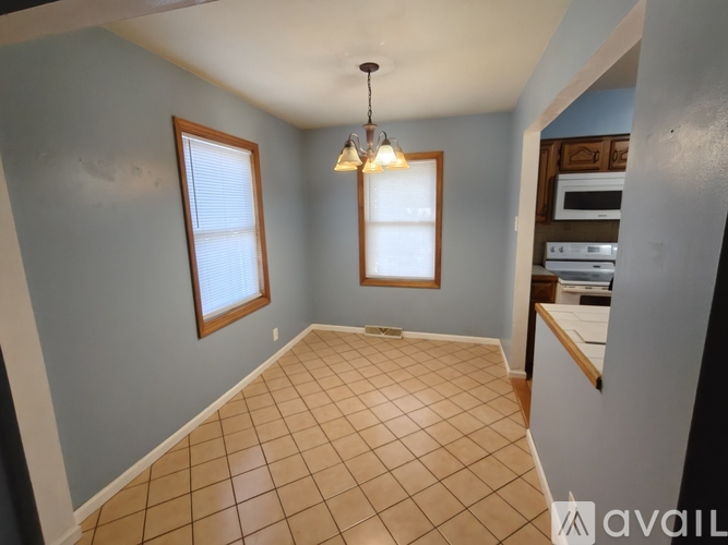 A room with tiled flooring and a chandelier hanging from the ceiling.