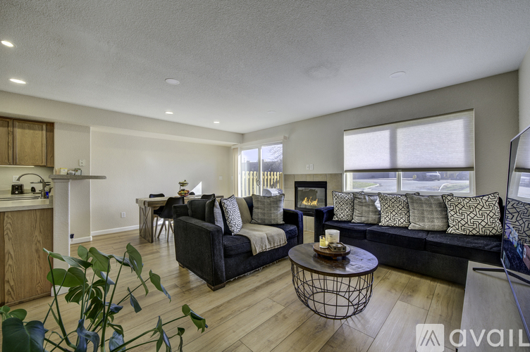 A living room with a black couch and a coffee table.