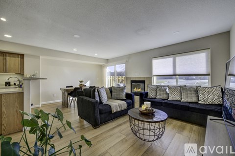 A living room with a black couch and a coffee table.