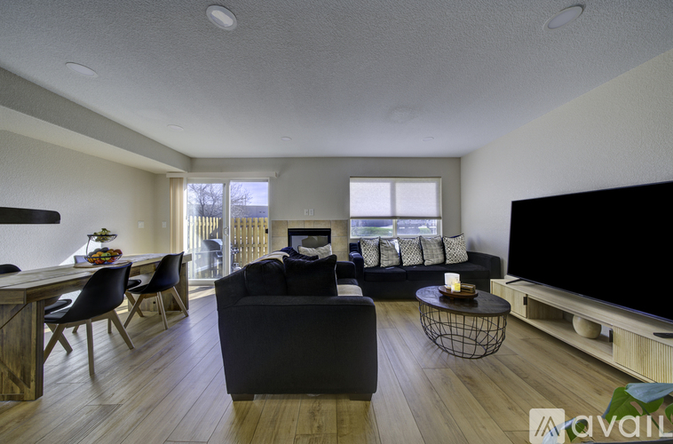 A living room with a black couch and a television.