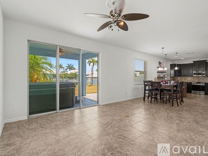 A spacious living room with a dining area and sliding glass doors leading to a balcony.