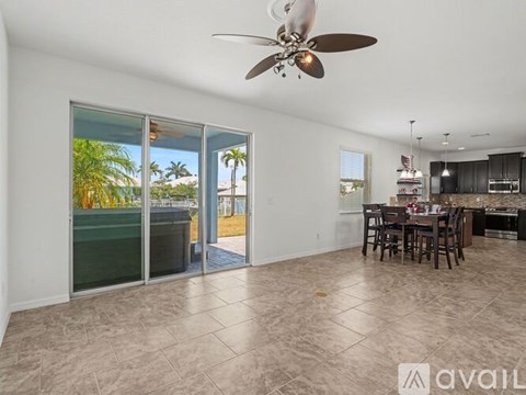 A spacious living room with a dining area and sliding glass doors leading to a balcony.