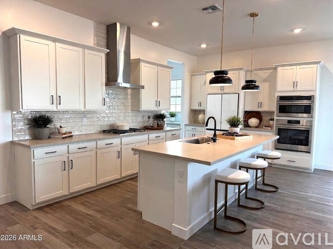 A kitchen with white cabinets and a large island.