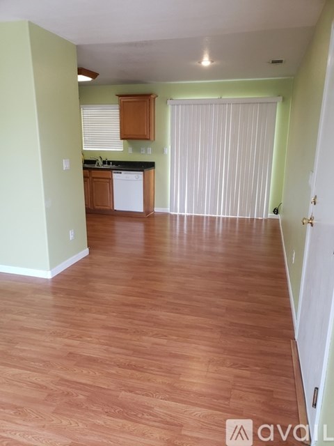A kitchen with wooden floors and green walls.