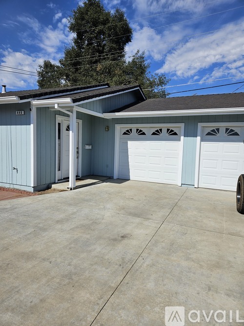 A two-car garage with a blue exterior and a white door is available for rent.