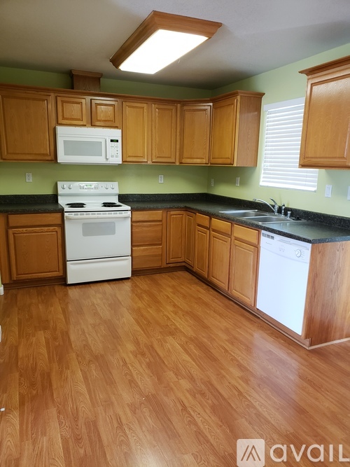 A kitchen with wooden cabinets and a white stove top oven.