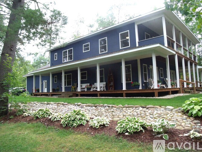 A blue house with white columns and a porch.