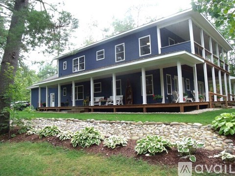A blue house with white columns and a porch.