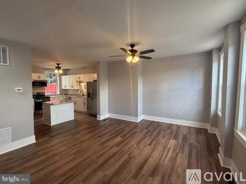 A room with wooden flooring and a ceiling fan.