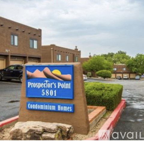 A sign for Prospector's Point Condominium Homes stands in front of a building.
