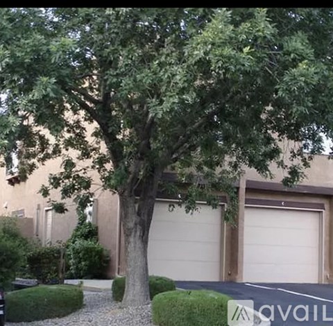 A tree in front of a building with a sign that says "available".