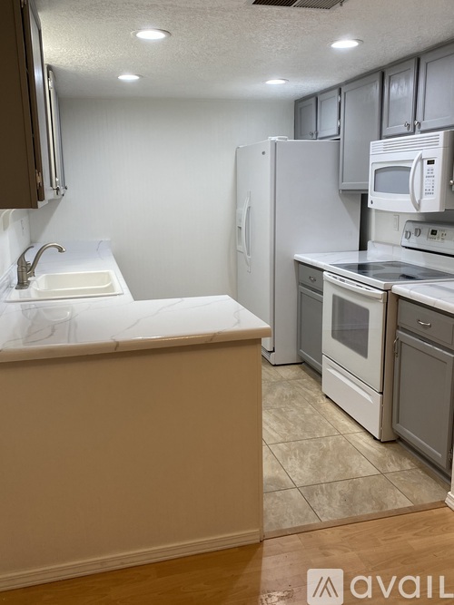 A kitchen with a white sink and a white refrigerator.