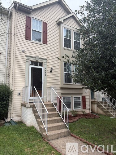 A two-story house with a front porch and stairs leading up to it.